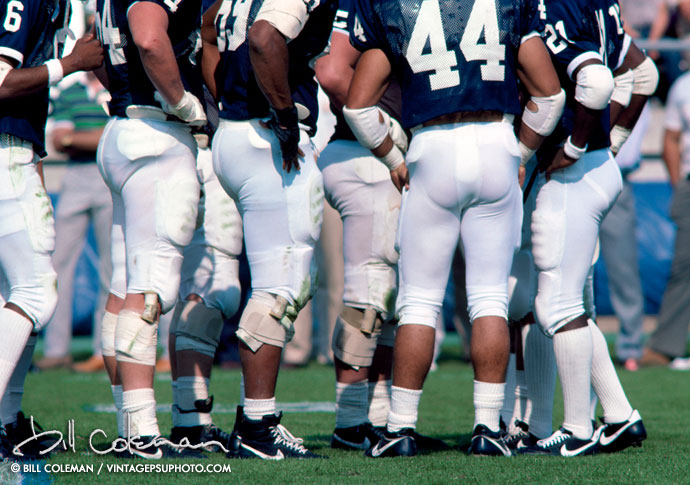 football players in a huddle seen from shoulders down